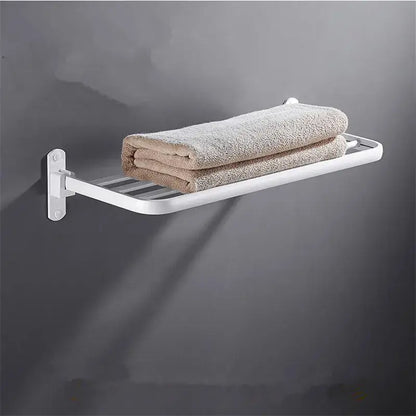 White metal wall-mounted decorbites aluminum towel rack holding two folded beige towels in bathroom setting