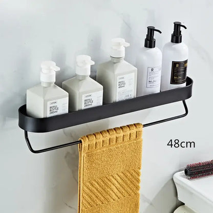 DecorBites™ black aluminum bathroom shelf with towel bar and corner storage shelf holding white pump bottles and towel