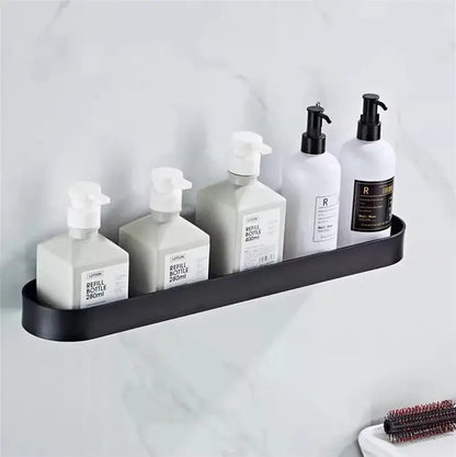 Black metal decorbites bathroom shelf with towel bar and corner storage shelf holding white and gray pump bottles