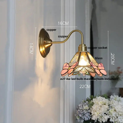 Vintage-style copper wall sconce with amber flower glass shade featuring pink butterfly and gold accents for living room lighting