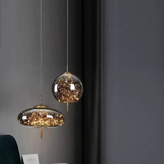 Decorbites amber glass chandelier featuring two modern glass pendant lights with golden fixtures and internal string lights
