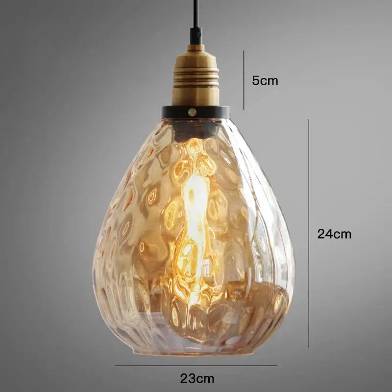 A warm amber glass industrial pendant light with textured glass and brass finish for dining and bedroom lighting