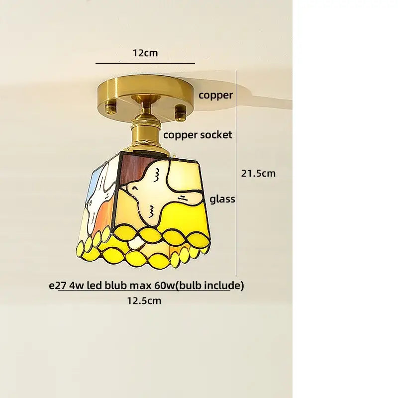 A DecorBites amber glass LED ceiling lamp with a yellow and white stained glass bird design and copper base
