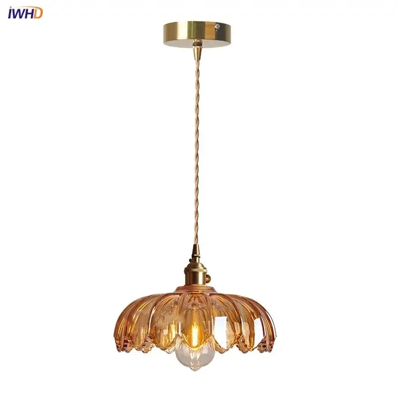Gold-toned decorbites pendant lamp with amber glass led petal shade and twisted brass cable in modern nordic style