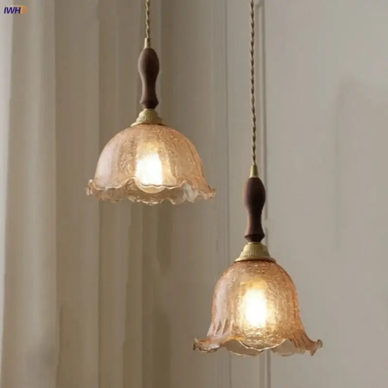 Two warm-toned amber glass led pendant lamps with walnut wood and copper fittings for elegant lighting decor