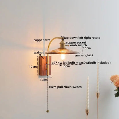 A warm-toned wall lamp with a copper arm, amber glass led shade, and walnut base by decorbites amber glass