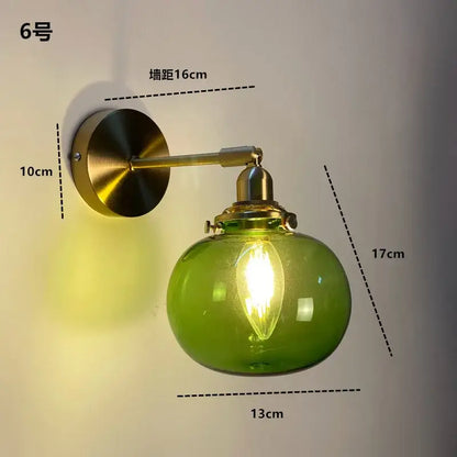 Green glass globe wall light fixture with brass hardware in a nordic modern style by decorbites
