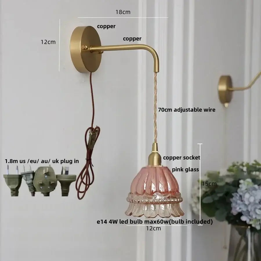 A delicate pink glass lampshade with a fluted design on a decorbites amber glass led wall light with copper arm