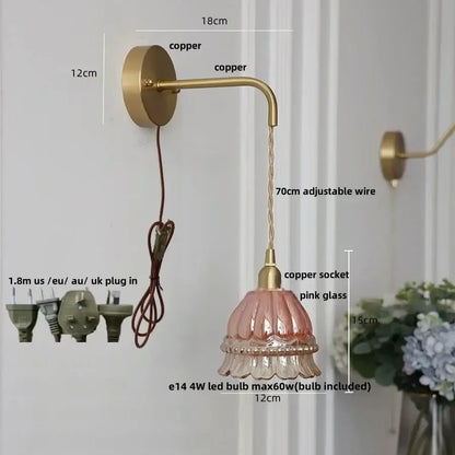 A delicate pink glass lampshade with a fluted design on a decorbites amber glass led wall light with copper arm