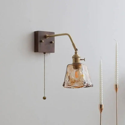 Brass wall sconce with decorbites amber glass led shade and adjustable arm featuring pull chain switch