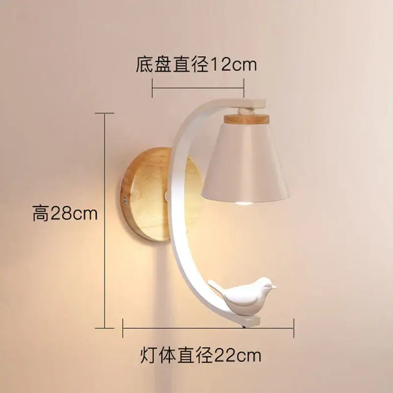 White ceramic bird perched on curved white metal arm of wooden base wall sconce for angel girl bedroom decor