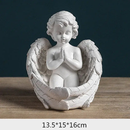White angel girl resin figurine with detailed feathered wings and clasped hands seated on a sculpted base for decor