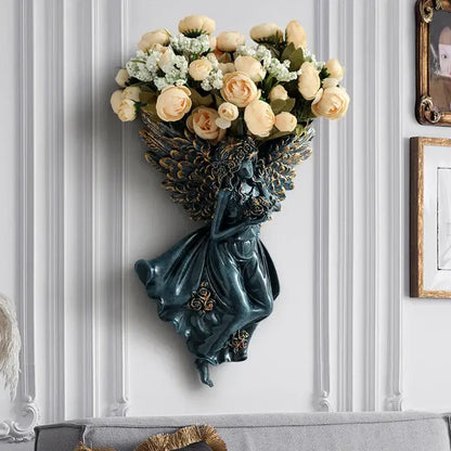Dark green resin angel vase wall decoration with ornate wings holding cream roses for living room shelf art