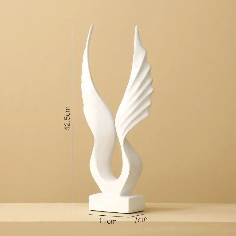 White ceramic angel wings sculpture with flowing forms on a square base for Nordic modern home decor