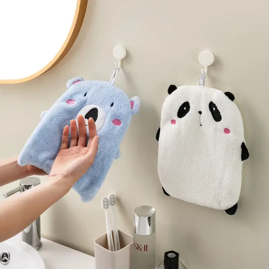 Blue plush bear-shaped bath sponge with pink cheeks hanging beside a white panda animal hand towel from decorbites hand towels set