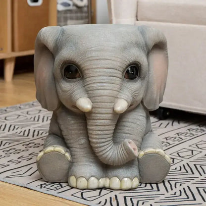 Gray resin baby elephant sculpture footstool seat with oversized ears glossy eyes and ivory tusks and feet by DecorBites