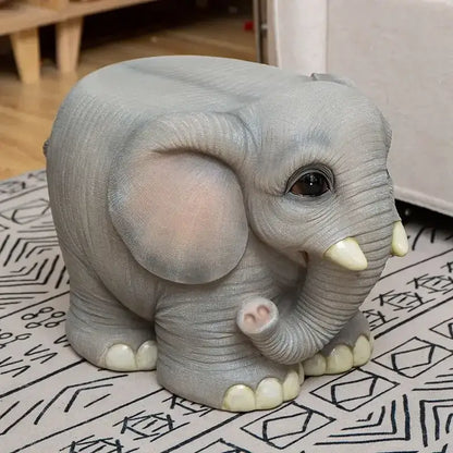 Gray elephant resin sculpture footstool seat with detailed textured skin and pink ears on a patterned surface