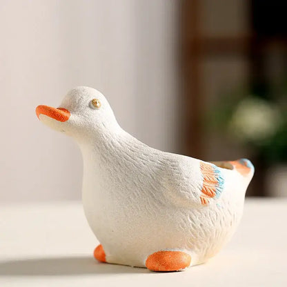 White ceramic animal vase succulent shaped like a duck with orange beak feet and wing accents for garden decor