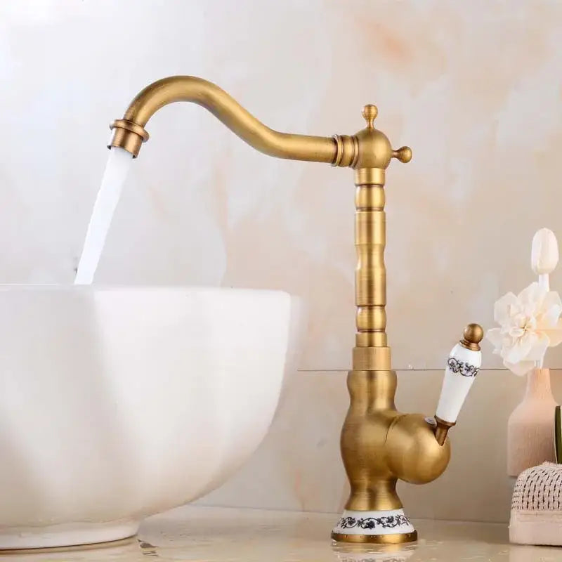 Decorbites antique brass basin faucet with curved spout and white ceramic handles featuring black floral patterns