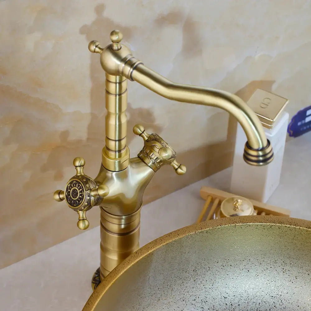 Decorbites antique brass carved kitchen faucet with ornate crown handles and curved spout in brass carved waterfall design