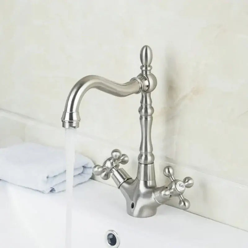 Stylish brushed stainless steel kitchen faucet with elegant curved spout and antique brass dual handle knobs