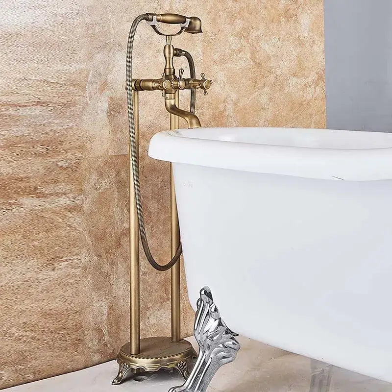 Decorbites™ antique brass freestanding bathtub filler with ornate spout and dual handles on pedestal base