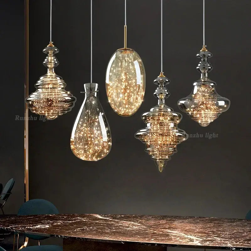 Set of five elegant brass glass chandelier pendant lights with antique brass glass and warm-toned filaments for dining room