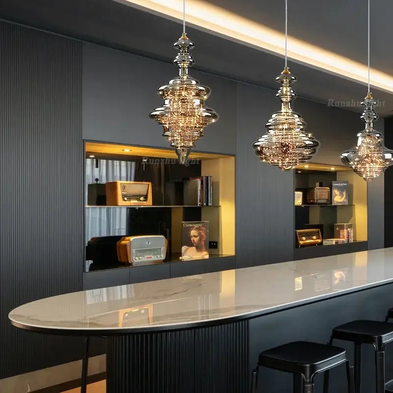 Three elegant tiered antique brass glass chandeliers with metallic finish for dining room and bar lighting