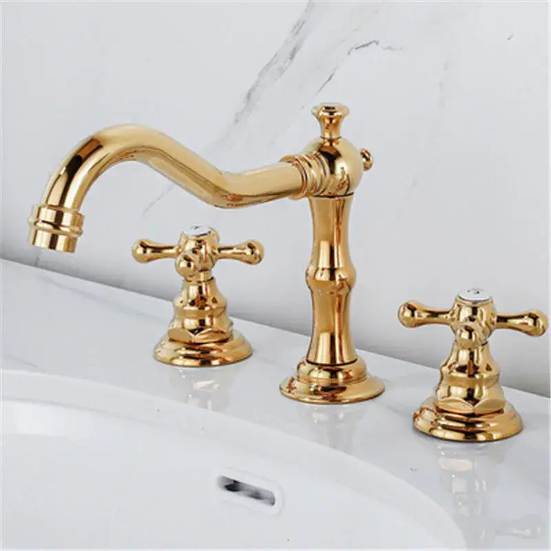 Decorbites antique brass gold bathroom basin faucet with three ornate cross handles and curved spout in brass gold bathroom finish