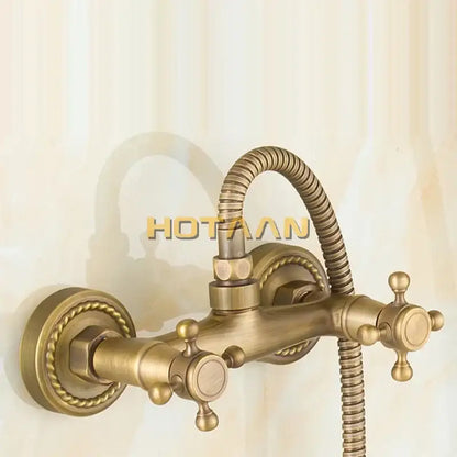 Antique brass hand held shower kit with wall mounted bathtub faucet featuring ornate twisted rope detailing and cross handles