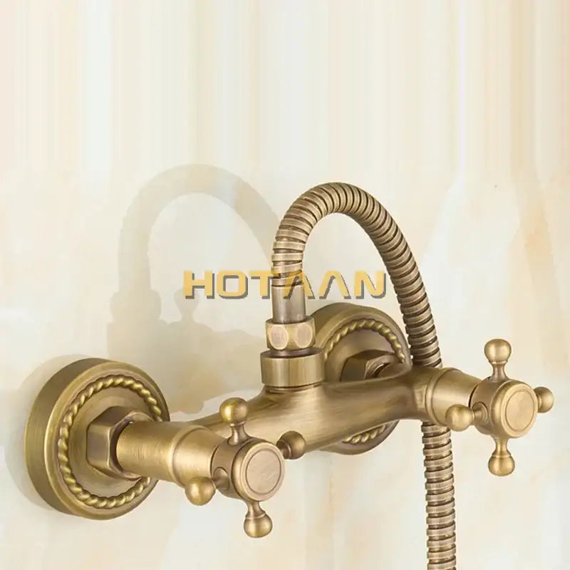 Antique brass hand held shower kit with wall mounted bathtub faucet featuring ornate twisted rope detailing and cross handles
