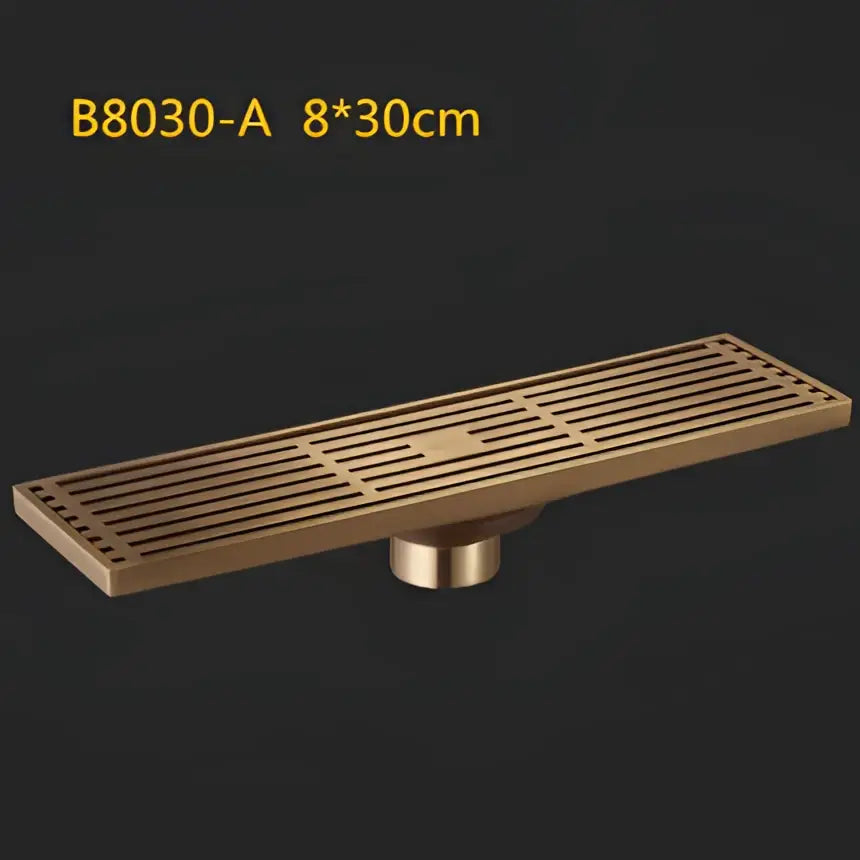 Bronze-colored antique brass linear floor drain with parallel slats and cylindrical mounting base for shower use