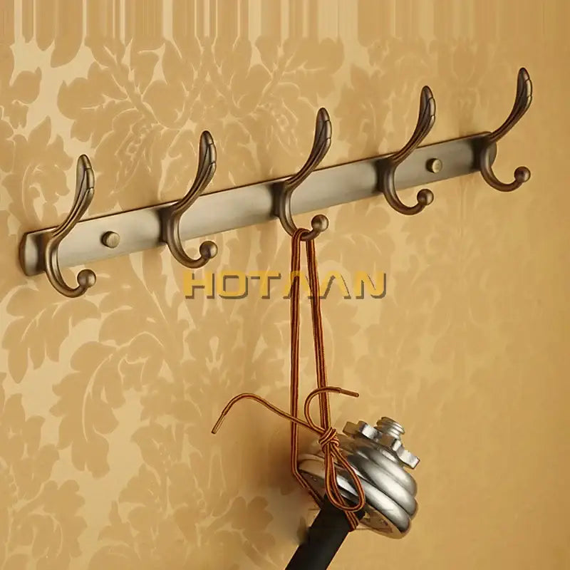 A sleek brushed metallic wall-mounted antique brass robe hook with five ornate hooks from decorbites bathroom accessories