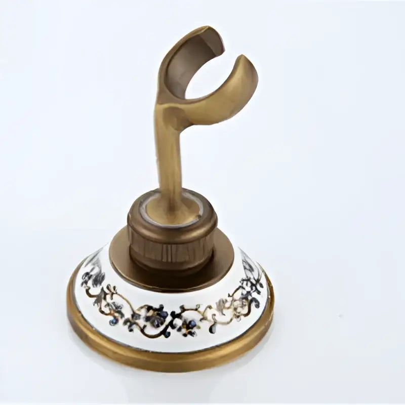 Antique brass shower faucet set with decorative white ceramic base featuring black floral patterns for bath use