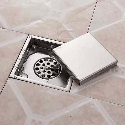 Square stainless steel floor drain with hinged lid and circular grate for antique brass shower drain use by DecorBites