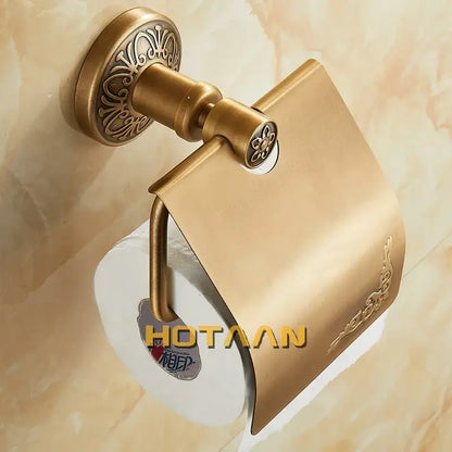 Brass toilet paper holder with ornate floral detailing and curved design in antique brass for classic bathroom use