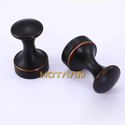 Decorbites™ antique brass wall robe hanger with black matte cabinet knobs and copper-toned accent rings