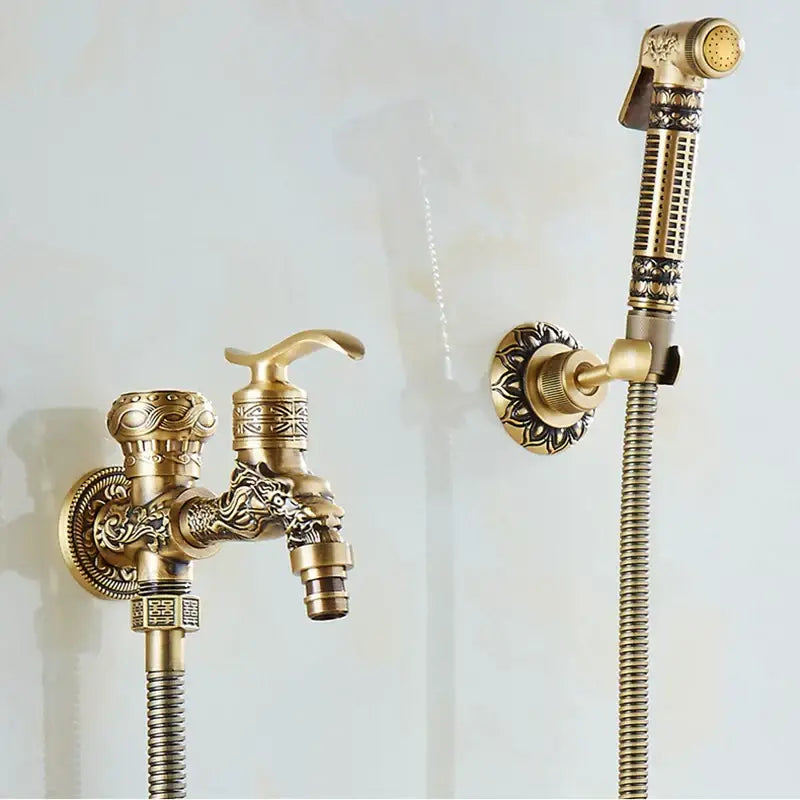 Brass wall mount bidet faucet with ornate dragon head design and matching handheld showerhead in antique brass finish