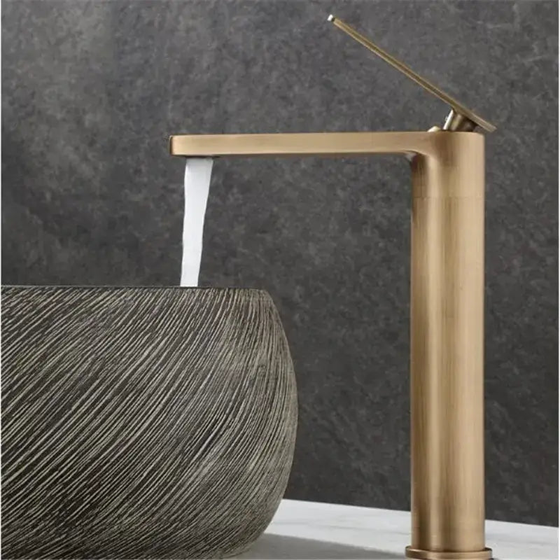 Decorbites™ antique bronze basin faucet featuring a brass finished modern waterfall spout and tall cylindrical body