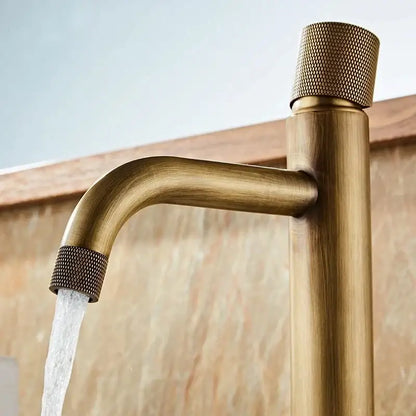 DecorBites™ antique bronze basin faucet with brass finish, textured knurled handles, and sleek curved spout for deck mounting