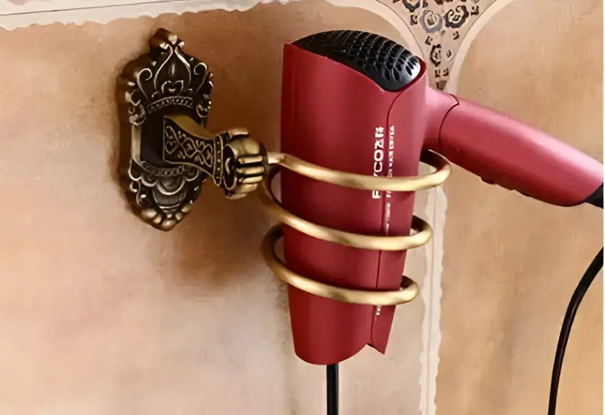 Red hair dryer on antique bronze carved aluminum wall mount with gold spiral holder in carved aluminum bathroom set