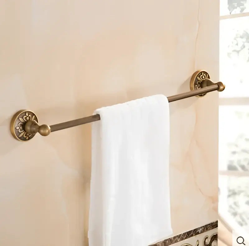 Decorbites antique bronze carved towel rack with ornate circular brass end caps holding white towel bathroom accessories set