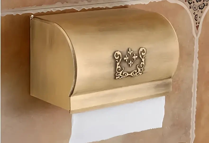 Gold-colored ornate metal toilet paper holder with decorative fleur-de-lis emblem from decorbites bathroom accessories set