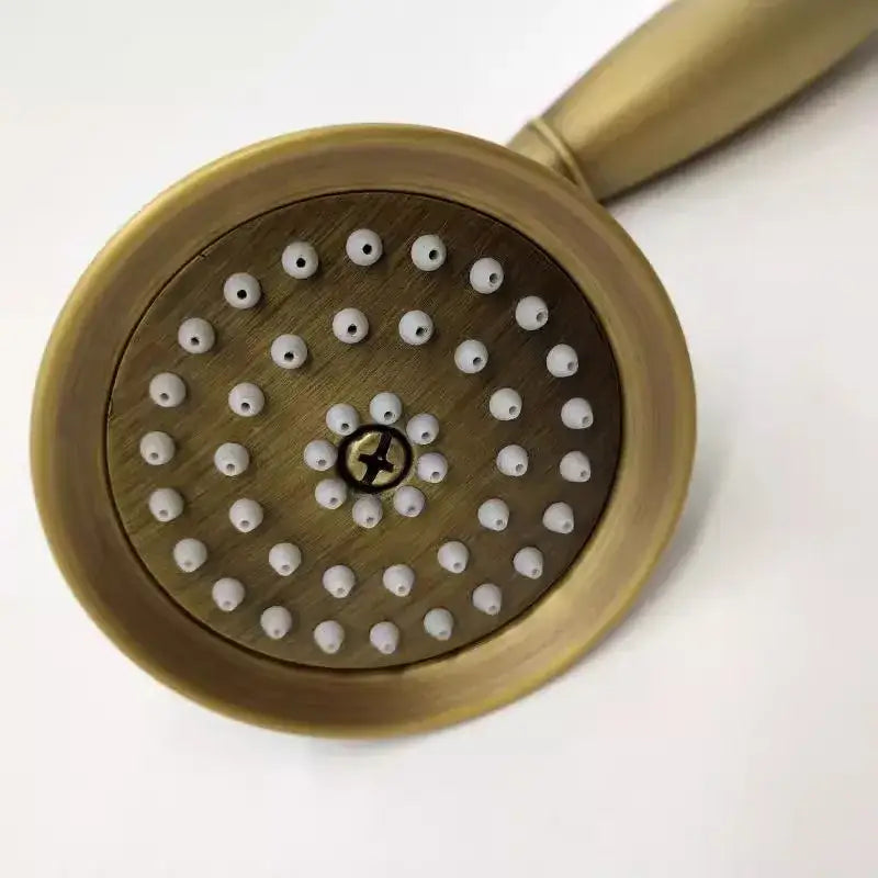 Antique gold handheld shower head by DecorBites featuring antique brass material with white ceramic nozzles and central screw