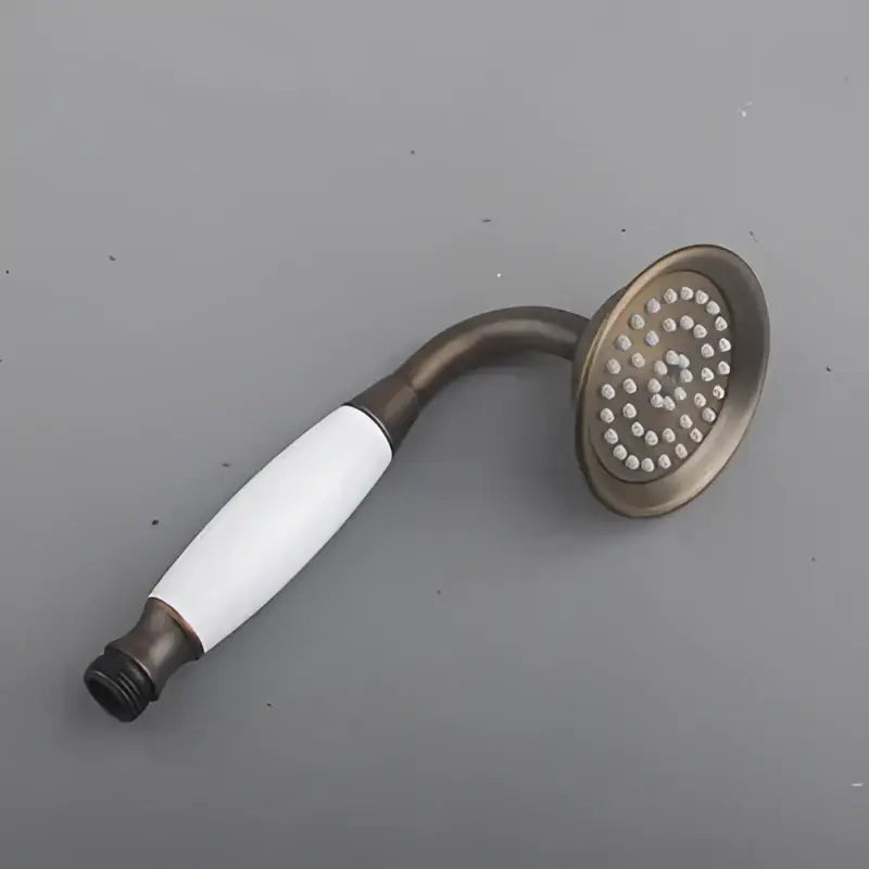 Decorbites antique brass shower head with white ceramic handle and circular nozzles in shower head holder stand