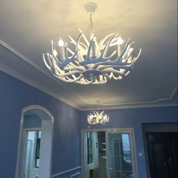 White antler chandelier with multiple illuminated bulbs in resin for rustic indoor decor by decorbites antler chandelier