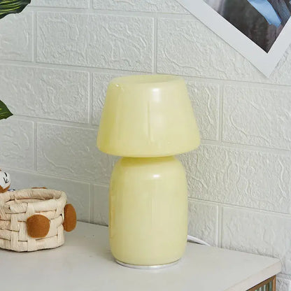 A sleek pale yellow decorbites apollo mushroom glass table lamp with smooth rounded design for bedside lighting