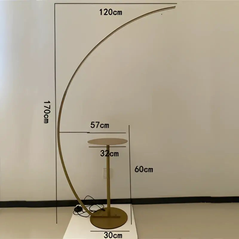 Gold-toned DecorBites Arc LED floor lamp with curved design and circular base in sleek Nordic minimalist style
