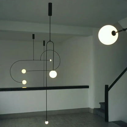 Modern black metal decorbites arc line chandelier with spherical frosted glass bulbs in geometric design for living spaces