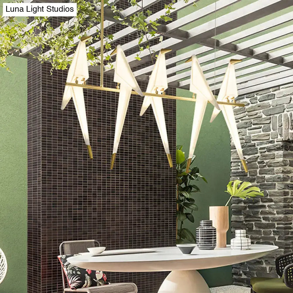 Modern white acrylic bird island pendant light with gold-toned metal accents featuring art deco design